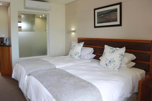 a bedroom with a large white bed with blue pillows at Blue Lagoon Hotel and Conference Centre in East London