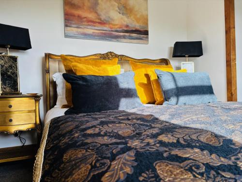 a bedroom with a bed with yellow and blue pillows at Sneaton Castle in Whitby