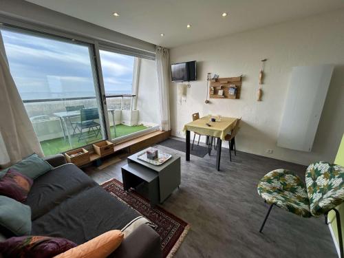 un salon avec un canapé et une table dans l'établissement Studio cosy à 100m de la plage avec balcon et parking - Saint-Jean-de-Monts - FR-1-224C-199, à Saint-Jean-de-Monts