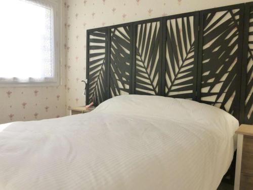 a bedroom with a white bed with a black headboard at Appartement 2 pièces avec parking privé, proche plage et commerces, Saint-Gilles-Croix-de-Vie - FR-1-224-783 in Saint-Gilles-Croix-de-Vie