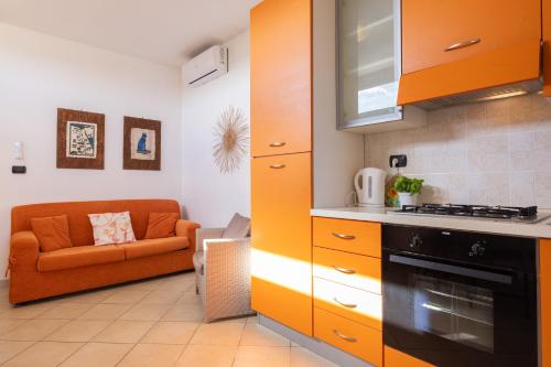 a kitchen with an orange couch in a room at Lucrezia - Relax, Piscina, Barbeque e Wi-Fi in Nardò