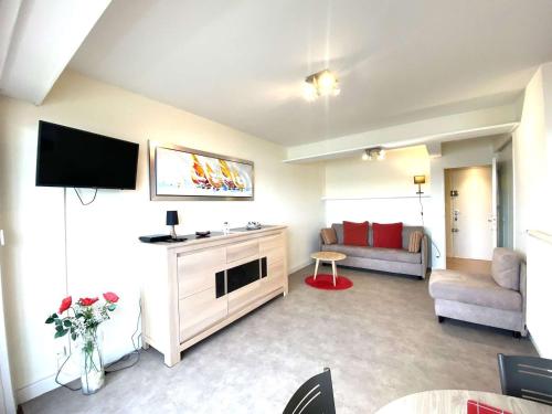 un salon avec une télévision et un canapé dans l'établissement Appartement 3* à Trégastel avec WIFI, parking, animal admis - FR-1-368-441, à Trégastel