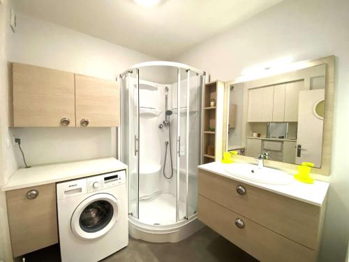 une salle de bain avec douche et machine à laver dans l'établissement Appartement 3* à Trégastel avec WIFI, parking, animal admis - FR-1-368-441, à Trégastel