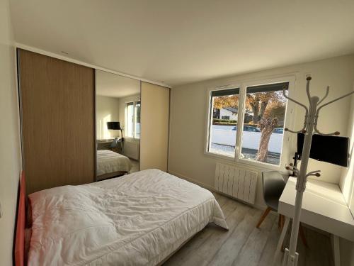 une chambre avec un lit et un grand miroir dans l'établissement Maison famille avec piscine, Wi-Fi et parking à Gujan-Mestras - FR-1-319-583, à Gujan-Mestras