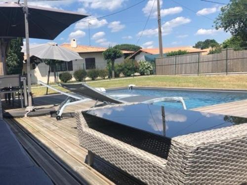 - une piscine avec un bain à remous et un parasol dans l'établissement Maison famille avec piscine, Wi-Fi et parking à Gujan-Mestras - FR-1-319-583, à Gujan-Mestras