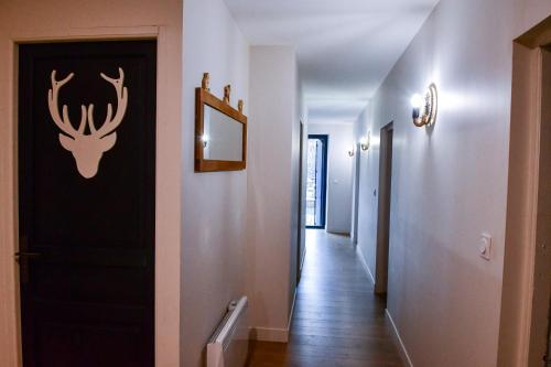 a hallway with a door with a deer head on the wall at Villa du Parc le Frêne in Formiguères