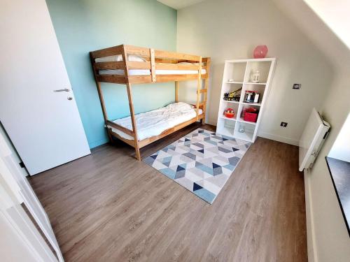 Cette petite chambre dispose de lits superposés et d'un sol. dans l'établissement Villa moderne 3 chambres avec jardin, WiFi et parking, proche plage - FR-1-675-44, à Wimereux