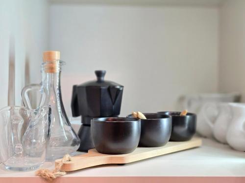 a group of cups sitting on a counter with a bottle at Forest Zen Małastów dom z prywatną balią z widokami na las in Małastów