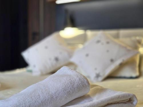 a towel on top of a bed with pillows at Forest Zen Małastów dom z prywatną balią z widokami na las in Małastów