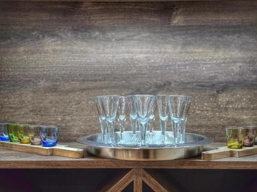 a tray with wine glasses on a wooden table at Forest Zen Małastów dom z prywatną balią z widokami na las in Małastów