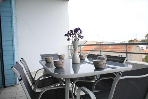 une table blanche et des chaises sur un balcon dans l'établissement Appt 3 pièces LA ROCHELLE - LR710-023, à La Rochelle