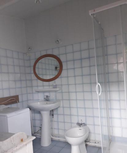 une salle de bain avec un lavabo, des toilettes et un miroir dans l'établissement villa soulacaise proche centre et plage, à Soulac-sur-Mer