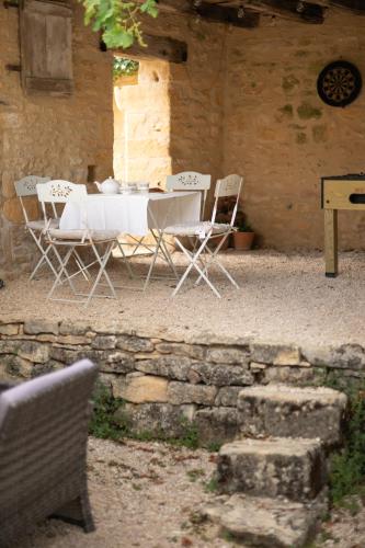 une table et des chaises assises à l'extérieur d'un bâtiment dans l'établissement Le Grand Gite au Manoir de Carlucet, à Saint-Crépin-et-Carlucet