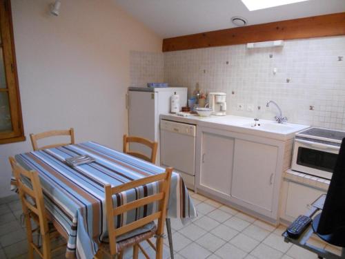 une cuisine avec une table et un réfrigérateur dans l'établissement villa soulacaise proche du marche, à Soulac-sur-Mer