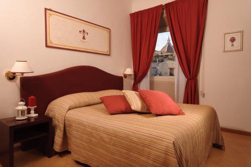 a bedroom with a bed with two pillows on it at Hotel Cardinal of Florence in Florence