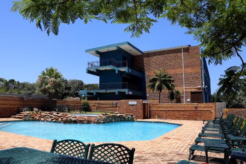 a swimming pool with a building in the background at Blue Lagoon Hotel and Conference Centre in East London