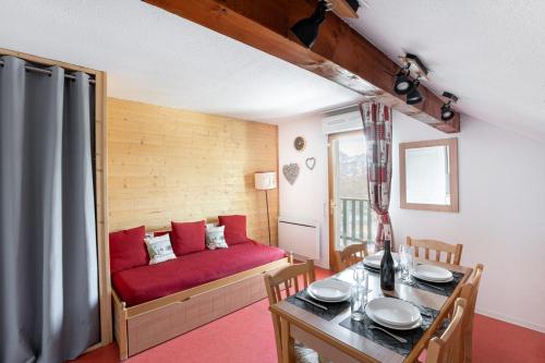 un salon avec un canapé rouge et une table dans l'établissement À 200m des pistes de ski, appartement pour 4, à Saint-Étienne-en-Dévoluy