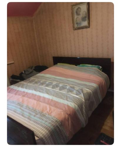 - un lit avec une couette rayée dans une chambre dans l'établissement Chez Miguel Angel, à Bonneuil-sur-Marne