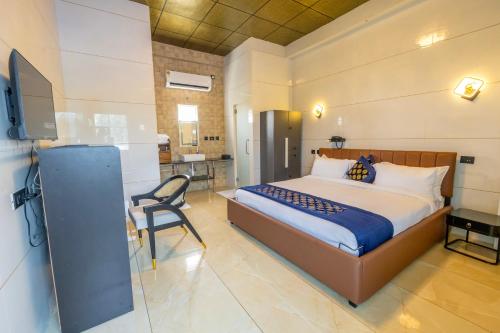a bedroom with a bed and a chair in a room at W&H View Residency in Cochin