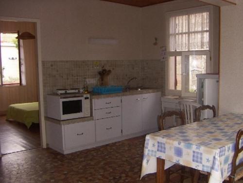 a kitchen with a stove and a table with chairs at soulac sur mer maison proche du marche in Soulac-sur-Mer