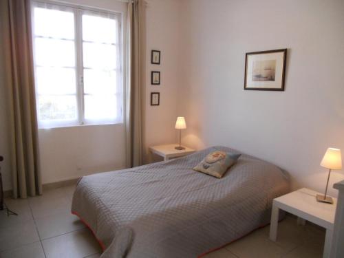 a bedroom with a bed with two tables and two lamps at soulac sur mer maison proche du marche in Soulac-sur-Mer