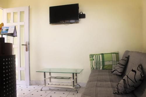 a living room with a couch and a table and a tv at Nui Nho Motel in Vung Tau