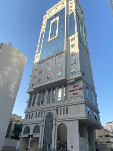 a tall building with a sign on the side of it at فندق اوتادالمتحدة الذهبي الروضة 4 in Al Khansāk