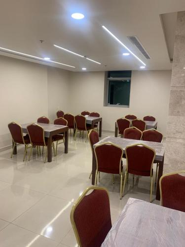 a class room with tables and chairs and a chalkboard at فندق اوتادالمتحدة الذهبي الروضة 4 in Al Khansāk