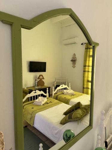two beds in a room with a mirror at Dar Lola Djerba in Houmt Souk