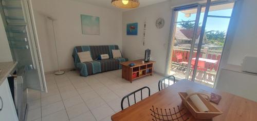 un salon avec un canapé et une table dans l'établissement appartement residence les vagues, à Soulac-sur-Mer
