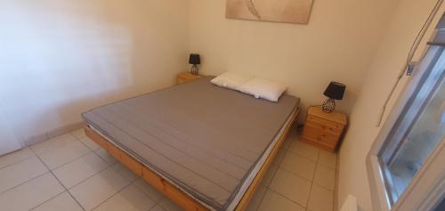 Un dormitorio pequeño con una cama en una habitación. en appartement residence les vagues, en Soulac-sur-Mer