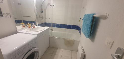 Un baño con lavabo y lavadora. en appartement residence les vagues, en Soulac-sur-Mer