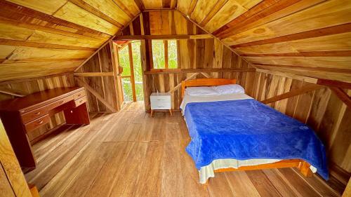 a bedroom with a bed in a wooden cabin at Finca Ecoparaiso in Ibagué