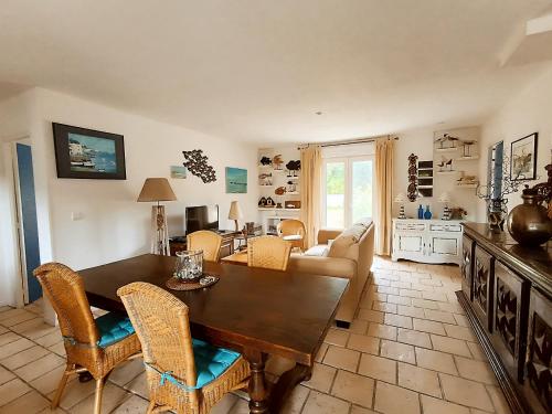 un salon avec une table et des chaises en bois dans l'établissement maison dans quartier residentiel, à Soulac-sur-Mer