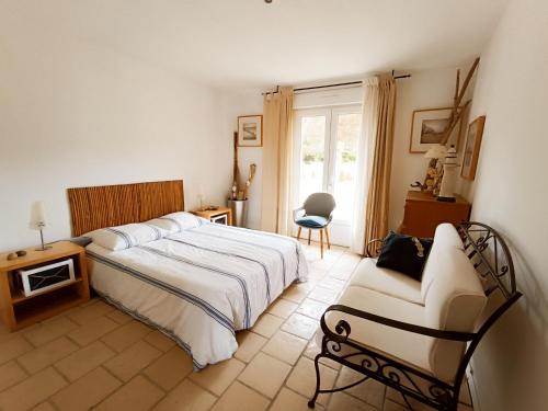 une chambre avec un grand lit et une chaise dans l'établissement maison dans quartier residentiel, à Soulac-sur-Mer