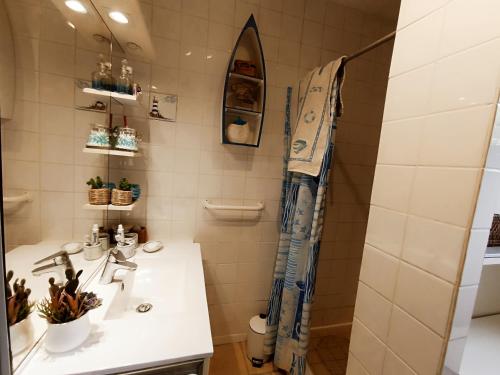une salle de bain avec un lavabo et une douche dans l'établissement maison dans quartier residentiel, à Soulac-sur-Mer
