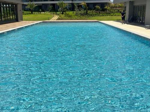 a large pool of blue water with a person standing in it at Minissy luxury Serviced Apartment in Moka