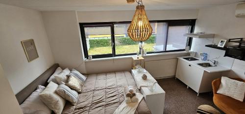 Una pequeña habitación con una cama y un lavabo. en Zion studio, en Almere