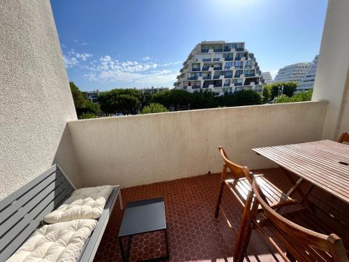 - un balcon avec un banc et une table dans l'établissement La Grande Motte - centre ville - 2 min de la plage, à La Grande Motte