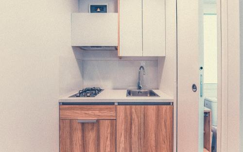 a kitchen with white cabinets and a sink at Club del Sole Tenuta Primero Grado Family Collection in Grado