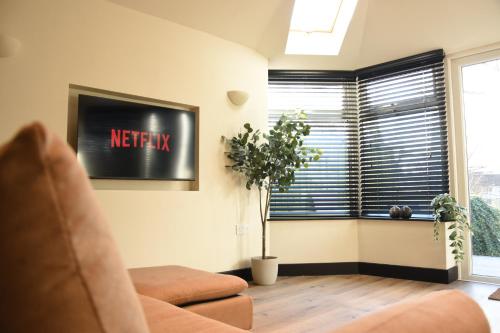 a living room with a couch and a window at Eden Escape - Bham Airport, NEC, HS2, JLR, Park Access in Sheldon