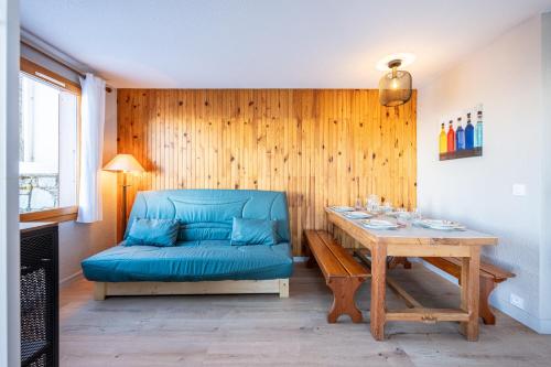 un salon avec un canapé bleu et une table dans l'établissement Le Sauget- au Chalet Bellevue Domaine La Plagne Paradiski, à Mâcot La Plagne