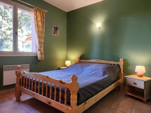 - une chambre avec un lit en bois dans un mur vert dans l'établissement Esquiròu Varois - Maison avec piscine, à Moissac-Bellevue