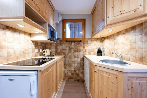 Il comprend une petite cuisine équipée d'un évier et d'un lave-vaisselle. dans l'établissement Les Verdons - Chalet Bellevue Domaine La Plagne, à Mâcot La Plagne