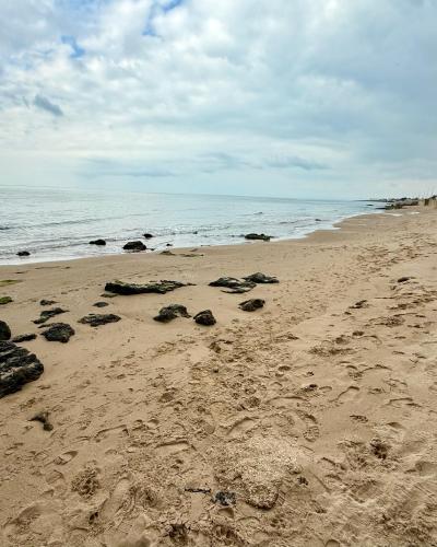 a beach with rocks in the sand and the ocean at LELE' Guesthouse in Scoglitti