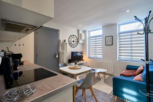 a kitchen and living room with a couch and a table at La Sister - Les Demeures d 'Adrien in Carvin