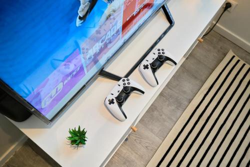a table with two video game controllers and a tv at La Sister - Les Demeures d 'Adrien in Carvin