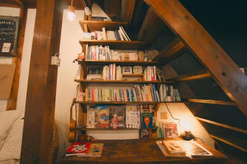 a book shelf filled with books in a room at 宿たぬきのねどこ GUESTHOUSE TANUKI in Tokoname