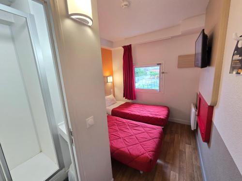 a small room with two beds and a window at Premiere Classe Thionville - Yutz in Basse-Yutz