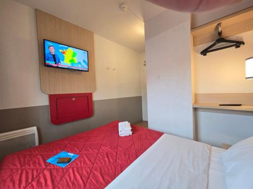 a bedroom with a bed with a tv on the wall at Premiere Classe Thionville - Yutz in Basse-Yutz